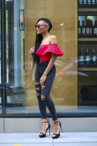 Ms Rexti in black ripped jeans and red bardot top